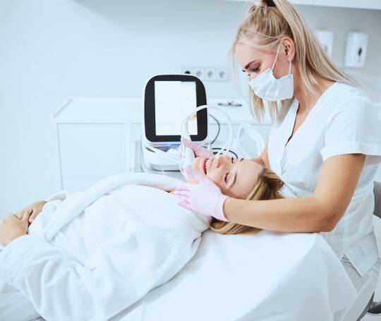 woman receiving a microneedling treatment from an aesthetician